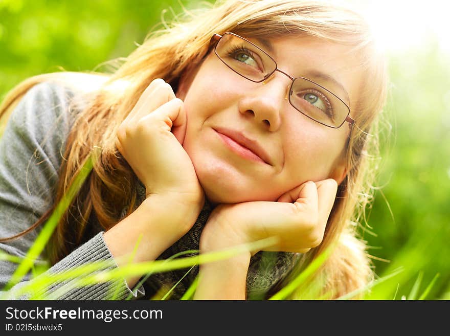 The young girl, lays on a green grass