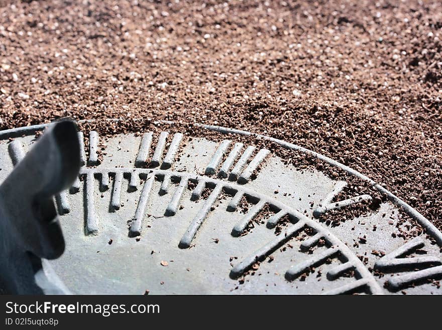 Ancient sundial lies on a dark ground.