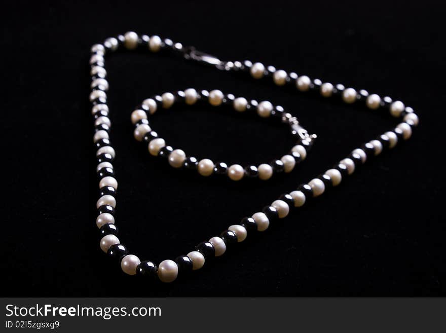 White pearls and black stone beads on a thread. White pearls and black stone beads on a thread