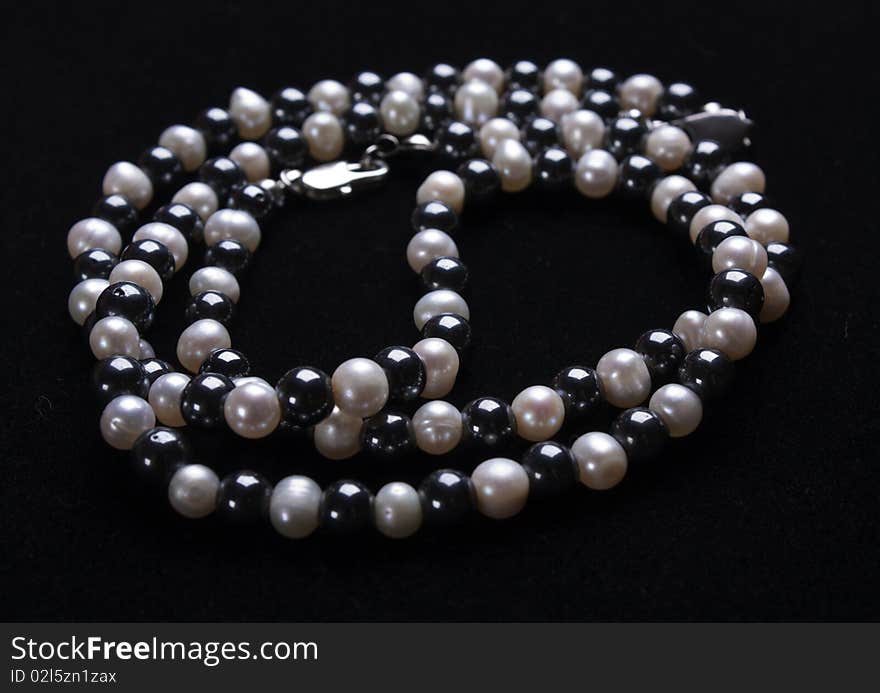 White pearls and black stone beads on a thread. White pearls and black stone beads on a thread