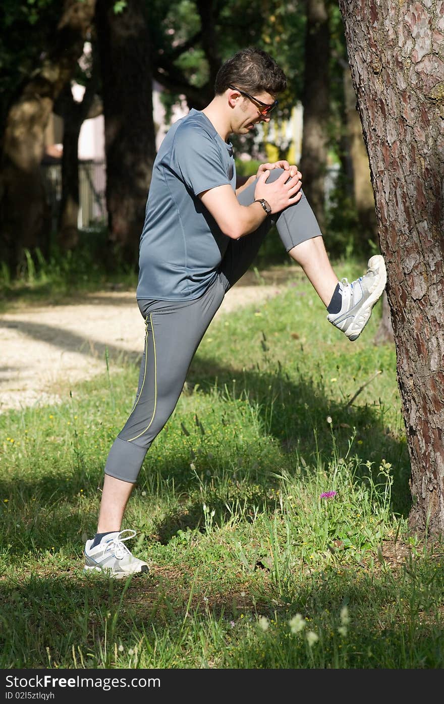 A middle age man making stretching movements before run