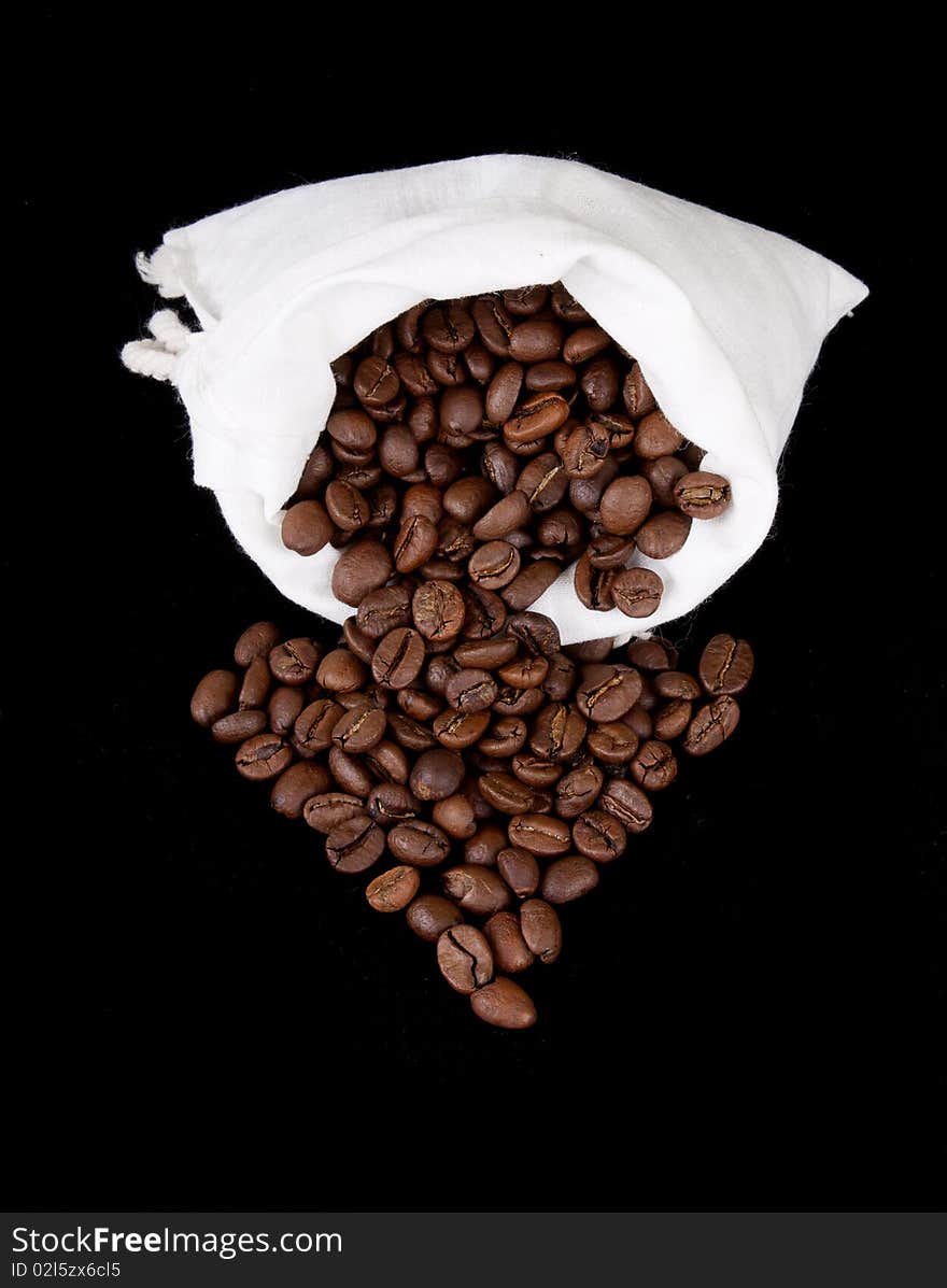 Coffee beans and burlap sack on black background