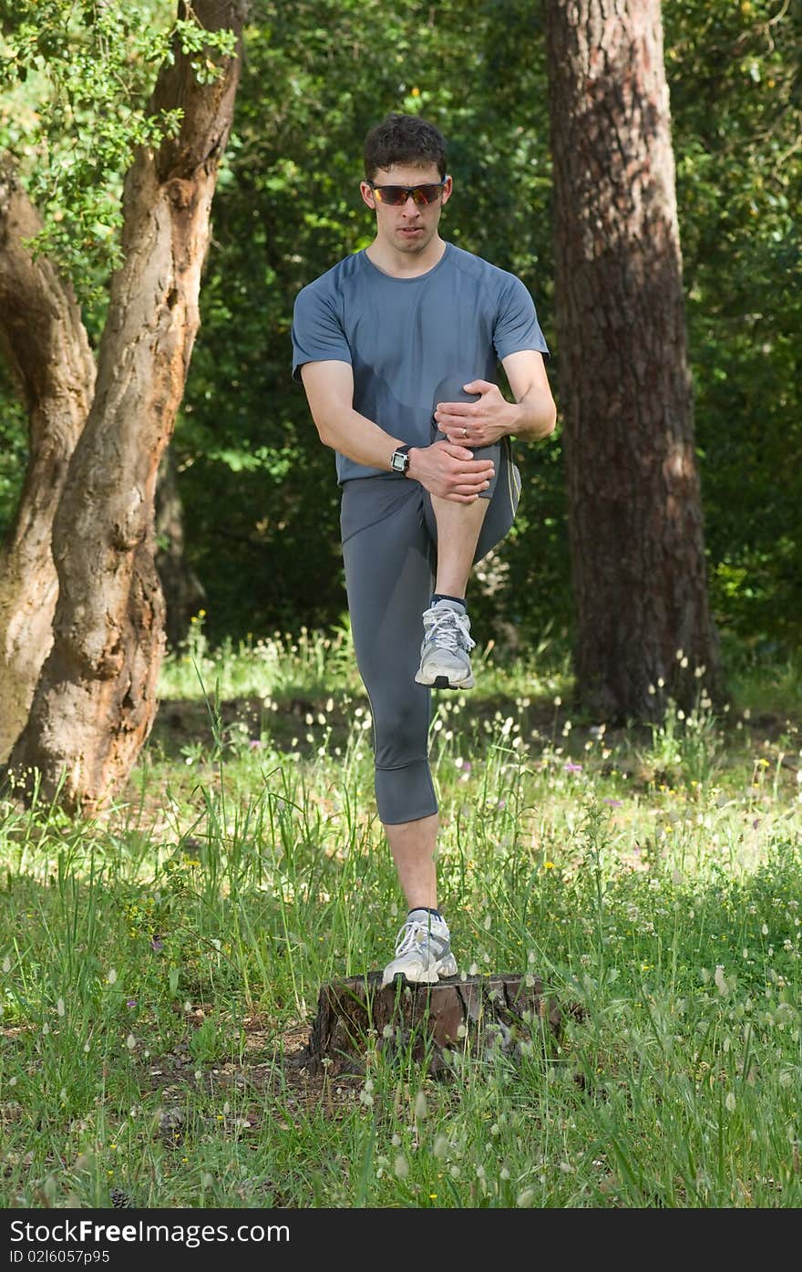 A middle age man making stretching movements before run