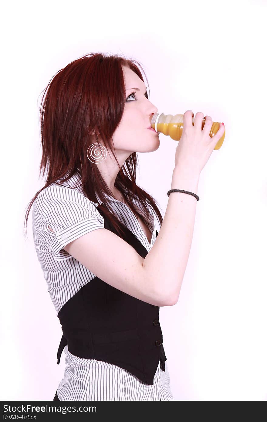 An attractive woman in office environment having a drink of juice. An attractive woman in office environment having a drink of juice.