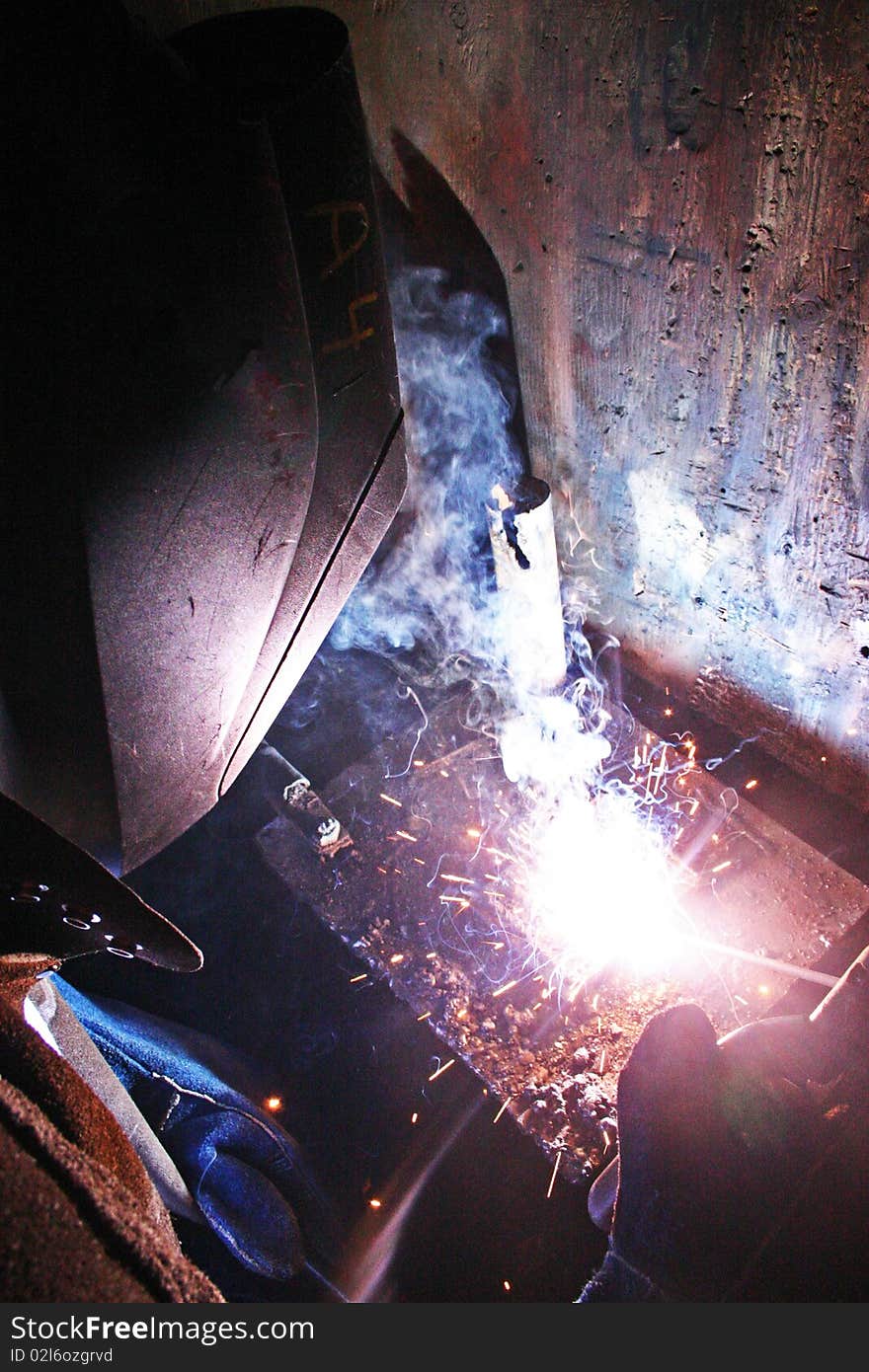 Man sitting and working on a welding project. Man sitting and working on a welding project