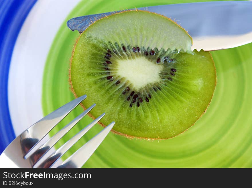 Kiwi, knife and fork on a plate