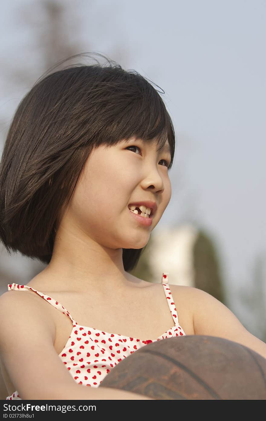 Asian girl holding basketball