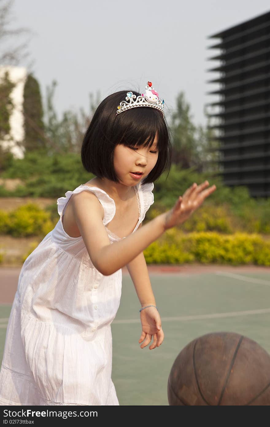 Asian girl bouncing basketball