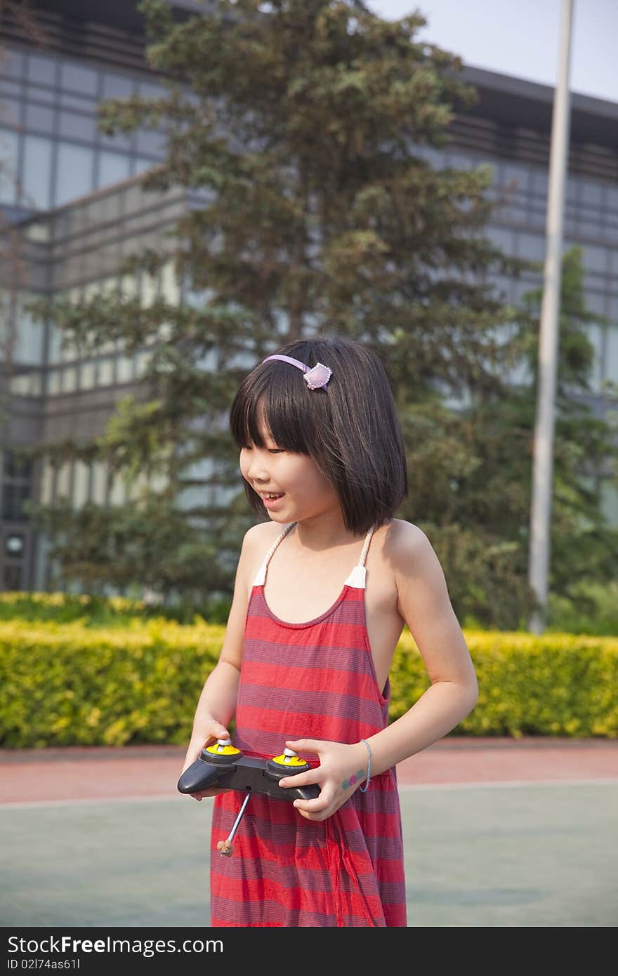 The asian girl is playing the remote controlled toy with great fun in summer. The asian girl is playing the remote controlled toy with great fun in summer