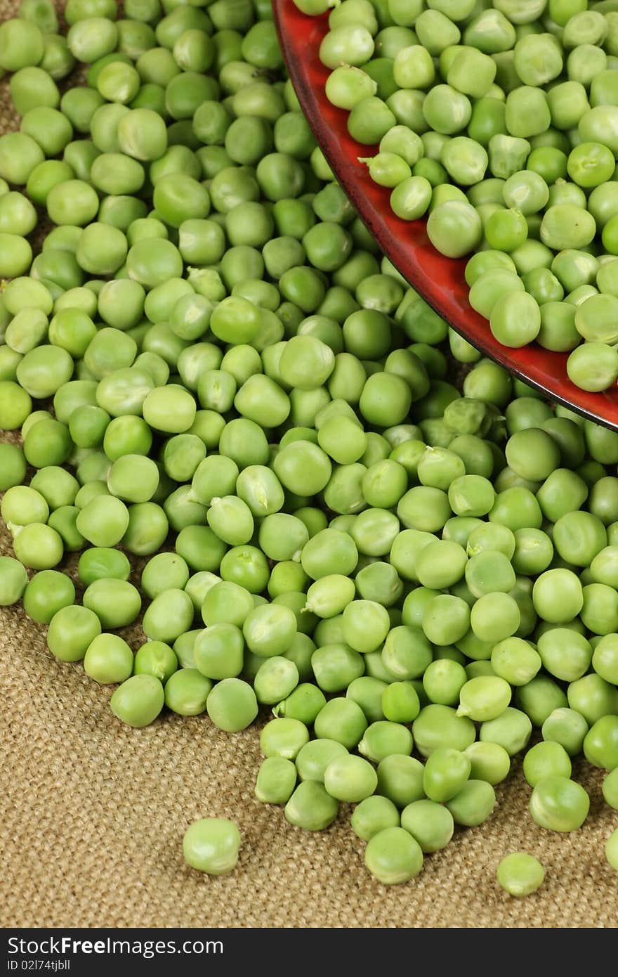 Pea, peas. a lot of pea on red plate studio shot