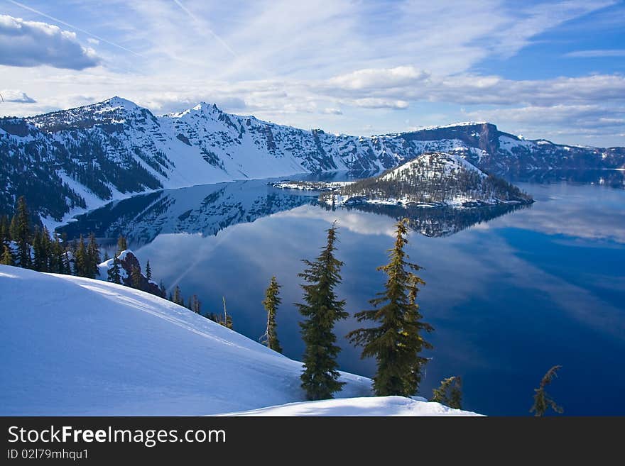 Crater Lake rim and lake still covered in snow early in the summer months. Crater Lake rim and lake still covered in snow early in the summer months