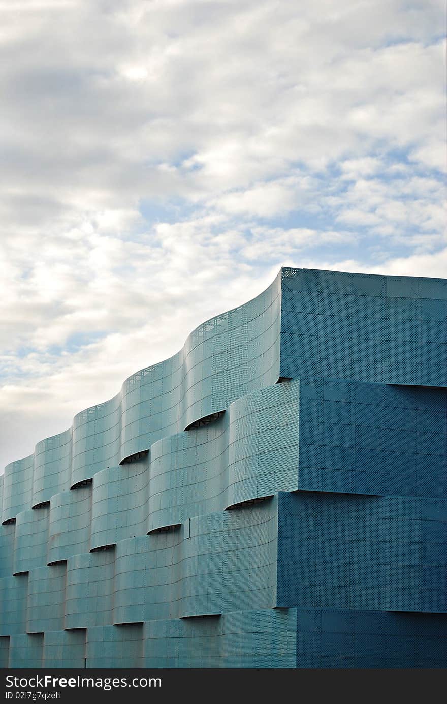 Blue Wavy Steel Clad Building on a Cloudy Day