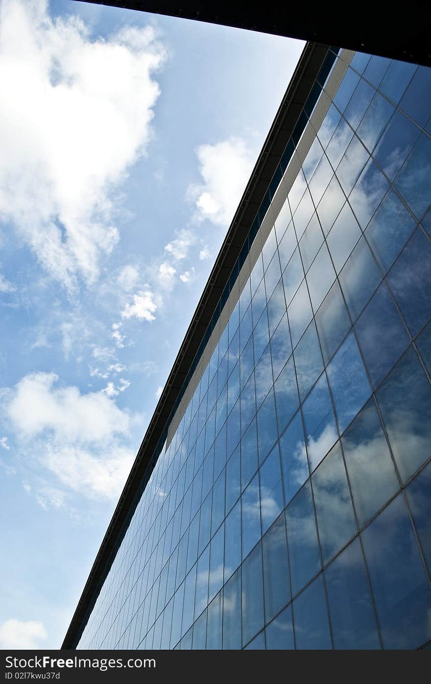 A building reflecting the blue sky on it's exterior. A building reflecting the blue sky on it's exterior