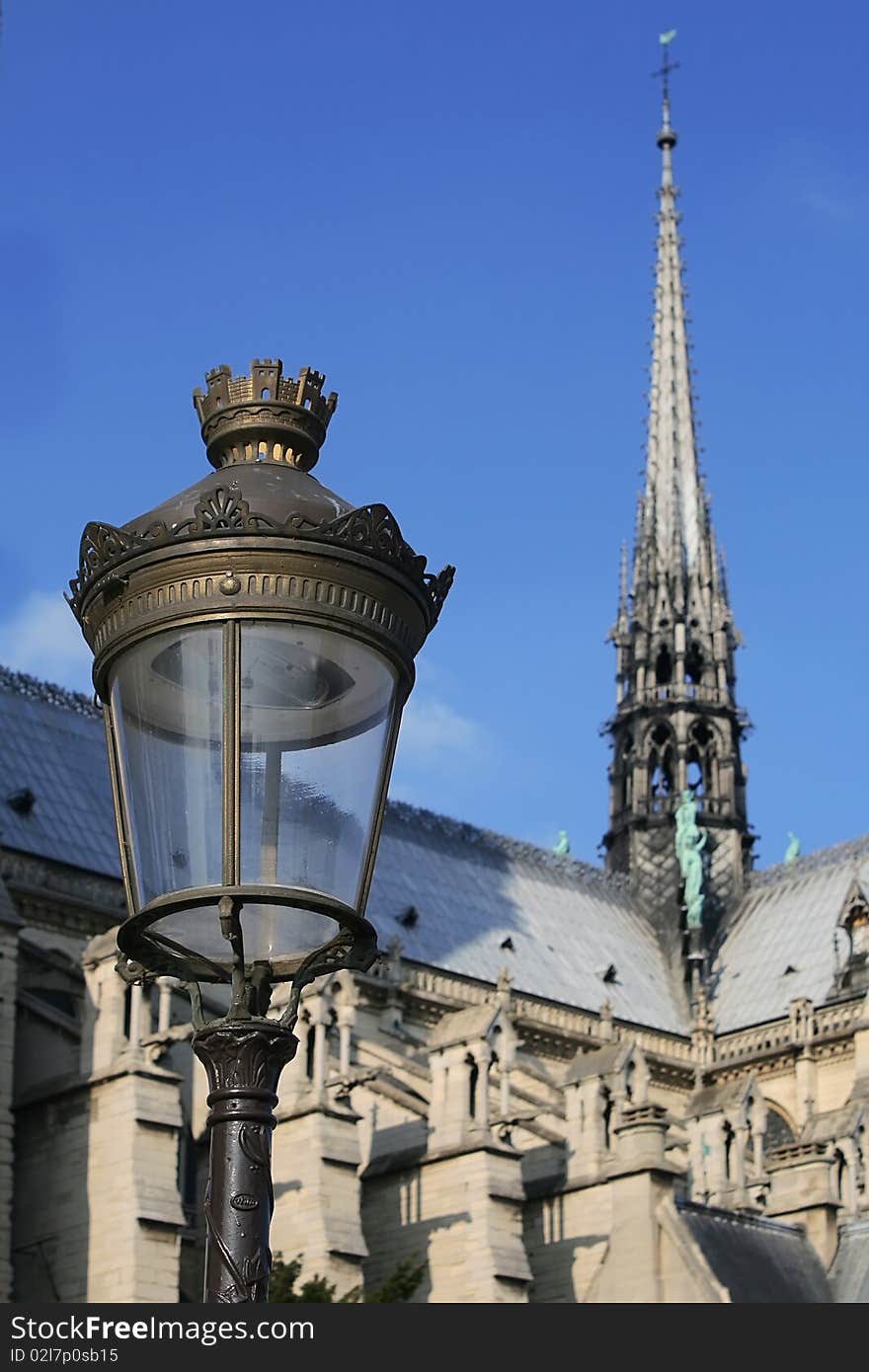 Paris street lamp against blue sky with Notre Dame Cathedral in background. Paris street lamp against blue sky with Notre Dame Cathedral in background