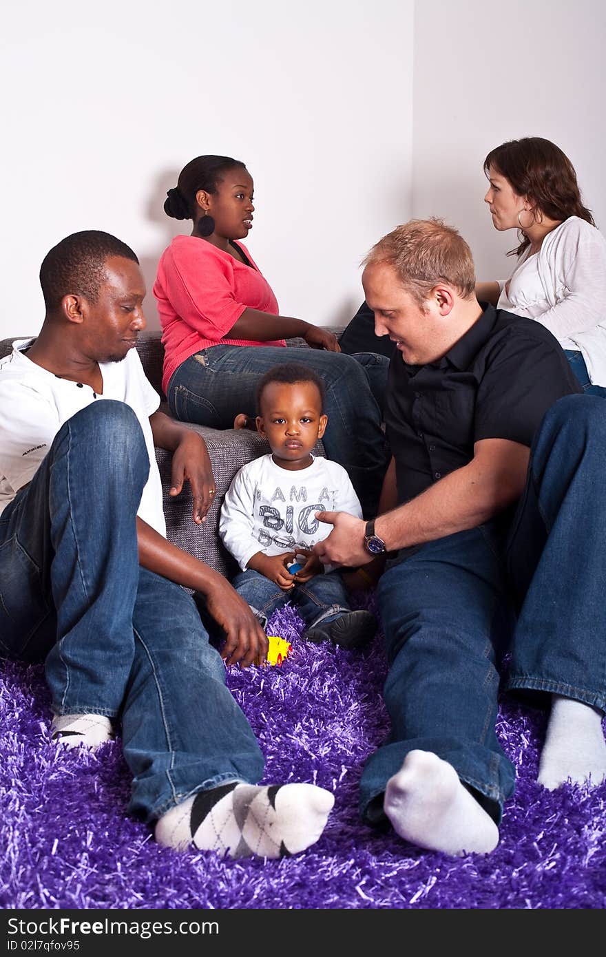 Young group of multiracial friends - two young families enjoying an afternoon meeting at home. Young group of multiracial friends - two young families enjoying an afternoon meeting at home.