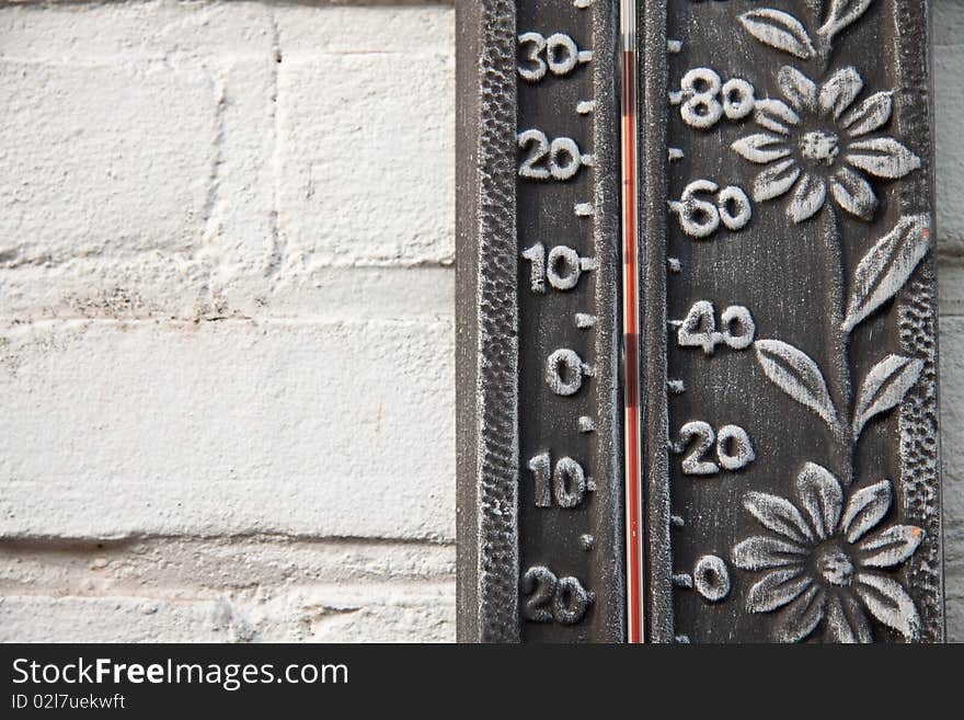 A Thermometer hanging against the white wall