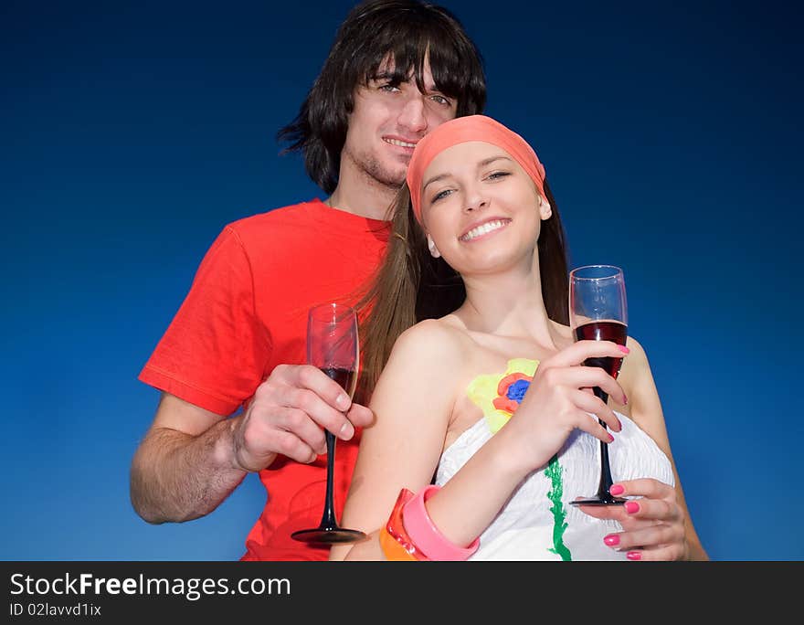 Girl and boy with wineglasses on blue background