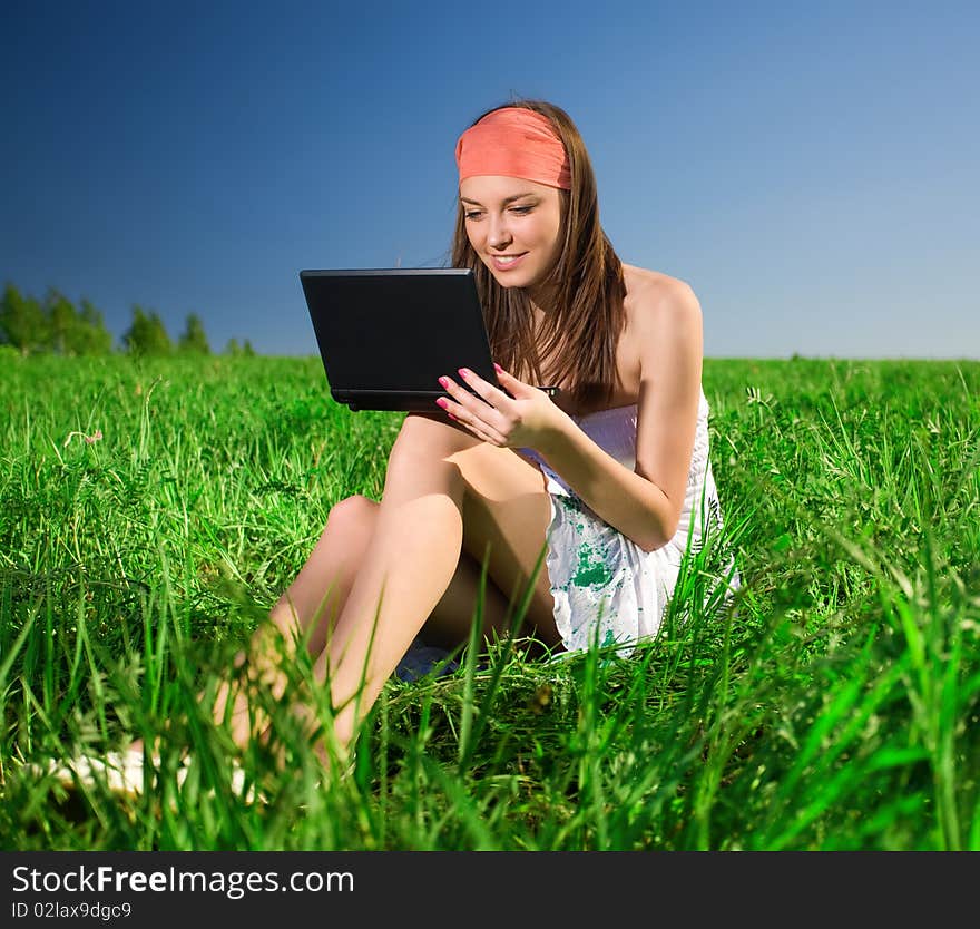 Beautiful girl with notebook on grass