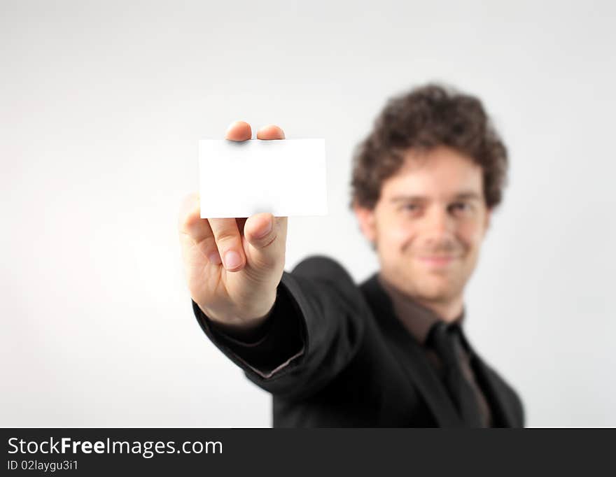 Smiling businessman showing a card. Smiling businessman showing a card