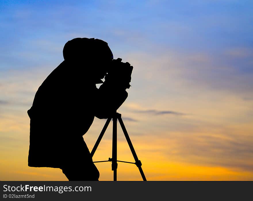 Photographer posing in sunset with beautiful sky. Photographer posing in sunset with beautiful sky