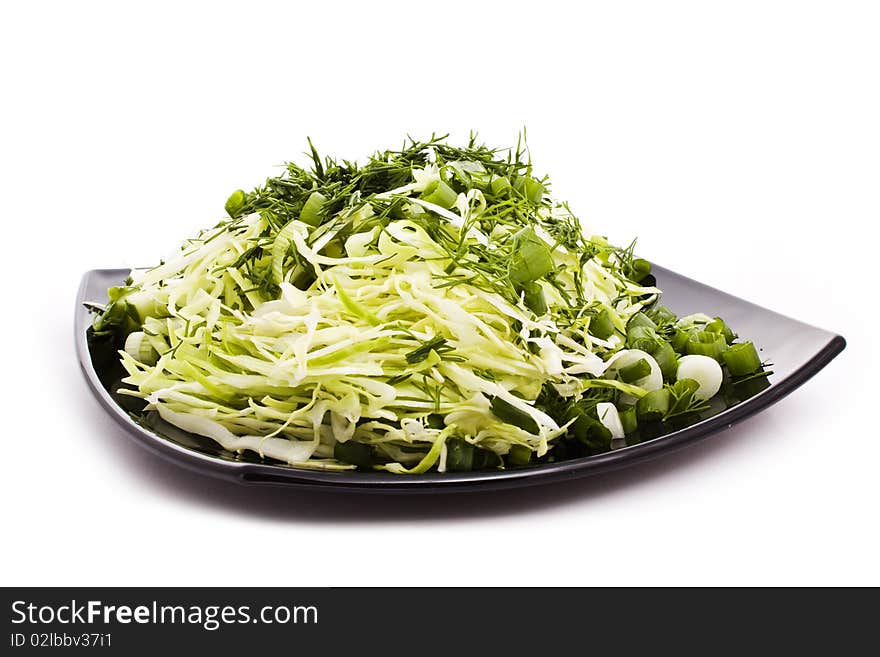 Green vegetarian salad on black plate isolated on white