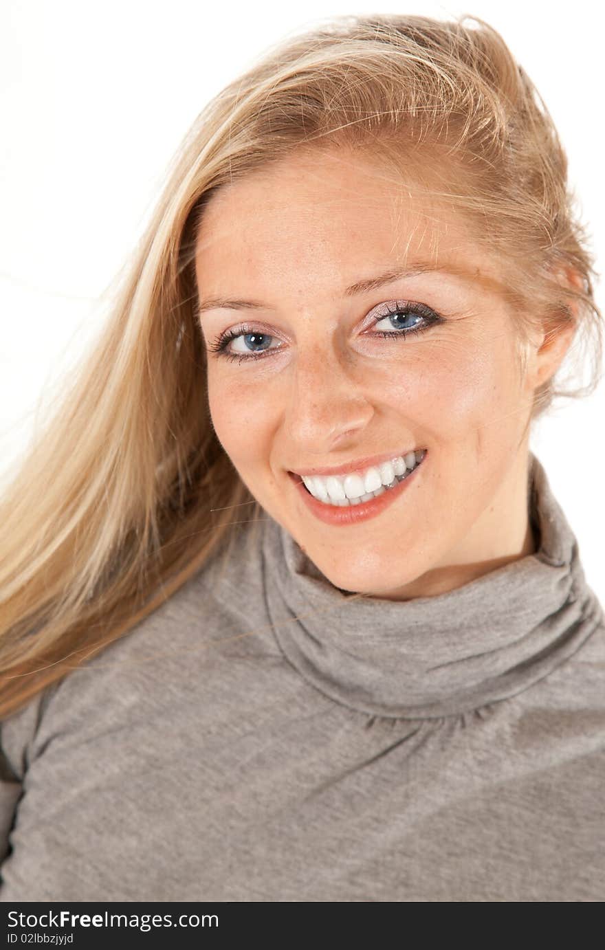 Caucasian blond girl portrait in gray outfit on white background smiling