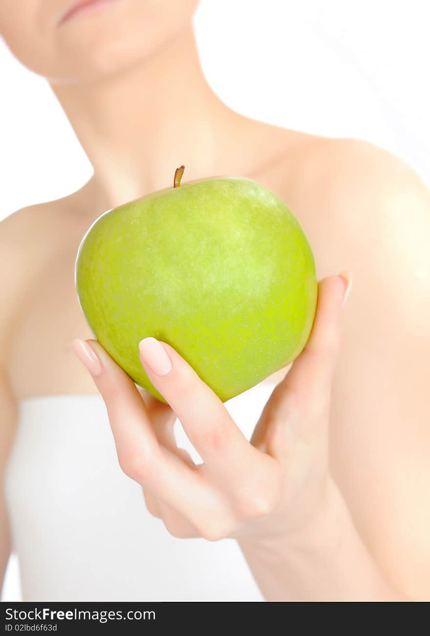 Green apple in a beautiful hand of woman. white background