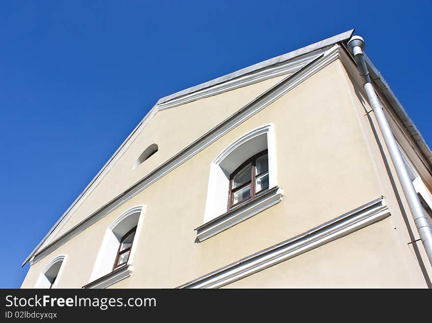 Yellow building with windows over blue sky. Yellow building with windows over blue sky