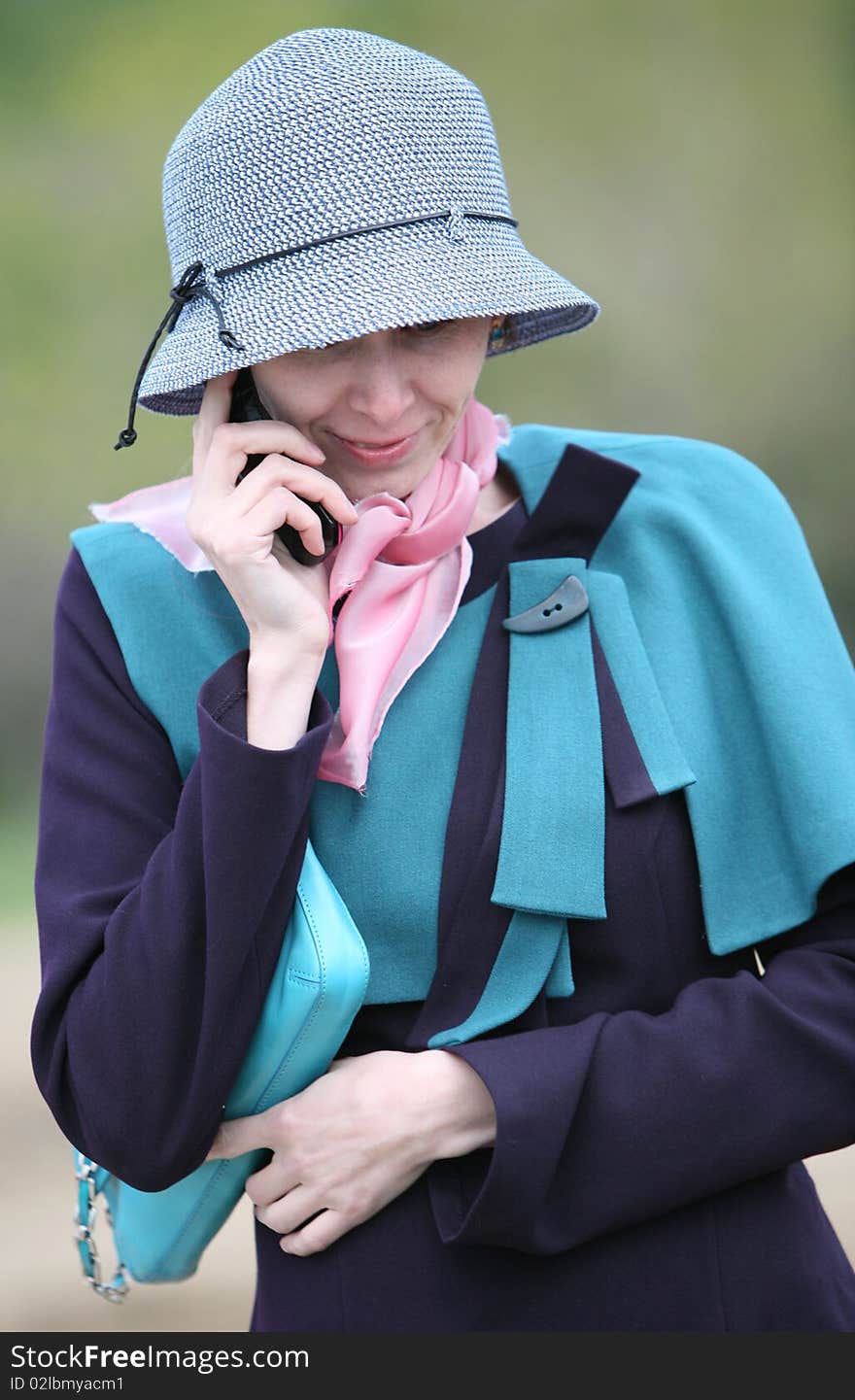 The portrait of smiling girl speak by the mobile phone