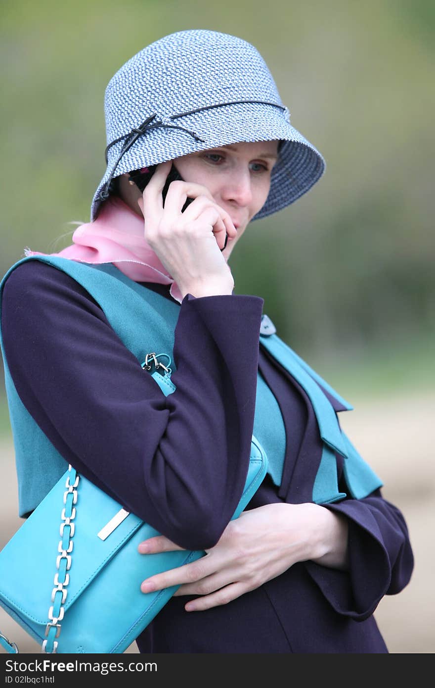 The portrait of smiling girl speak by the mobile phone