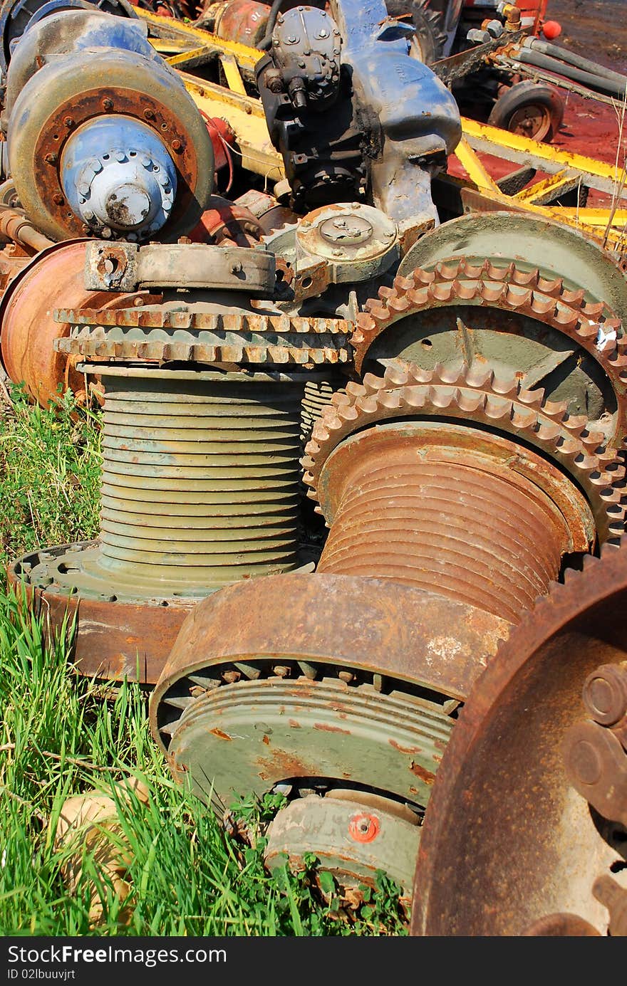 Old rusty gears of the machine on the grass.