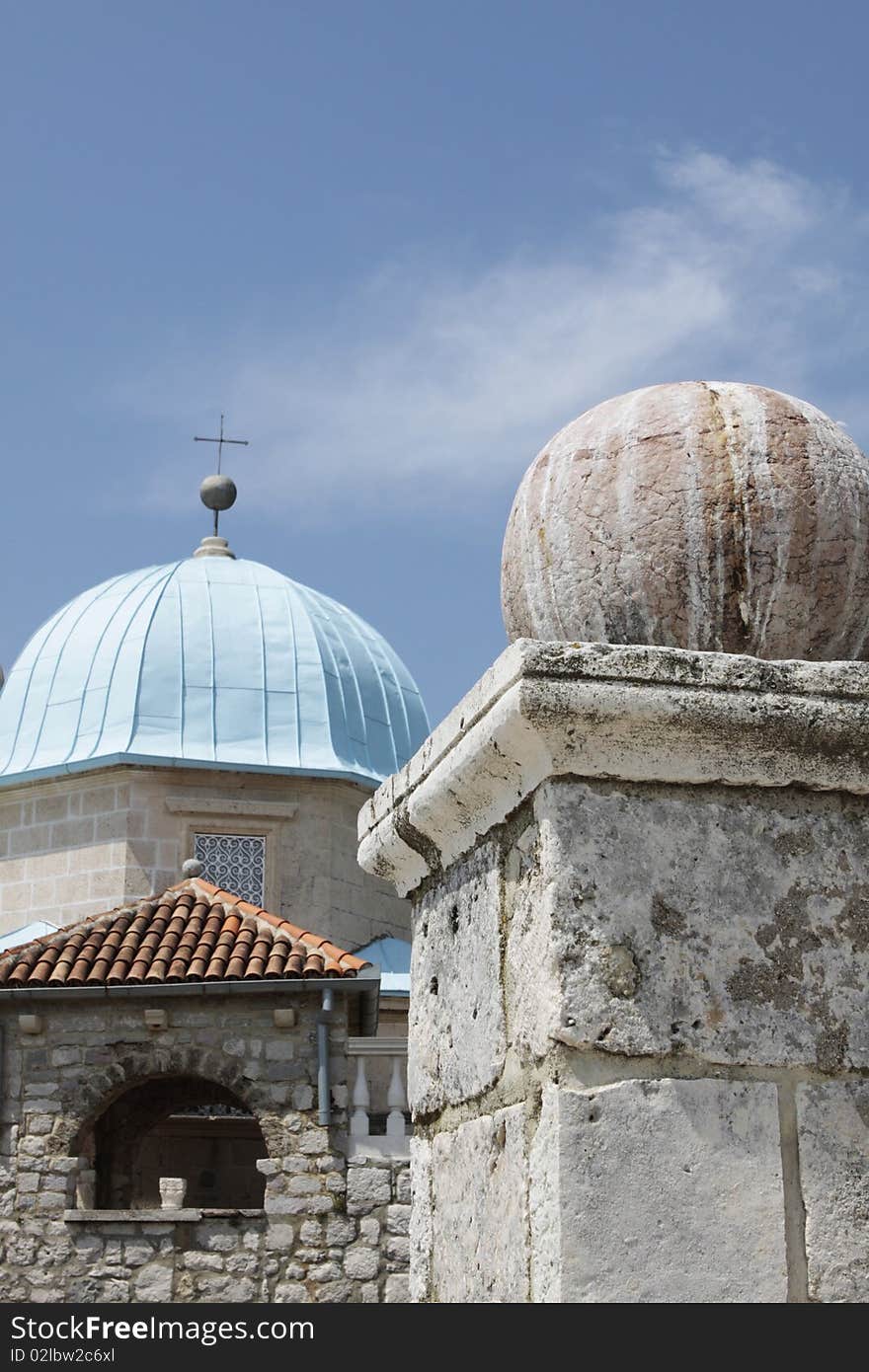 Stone sphere on a pedestal against blue domes of Montenegro church. Stone sphere on a pedestal against blue domes of Montenegro church.