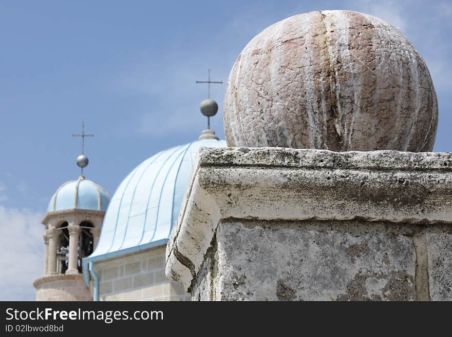 Stone sphere on a pedestal against blue domes of Montenegro church. Stone sphere on a pedestal against blue domes of Montenegro church.