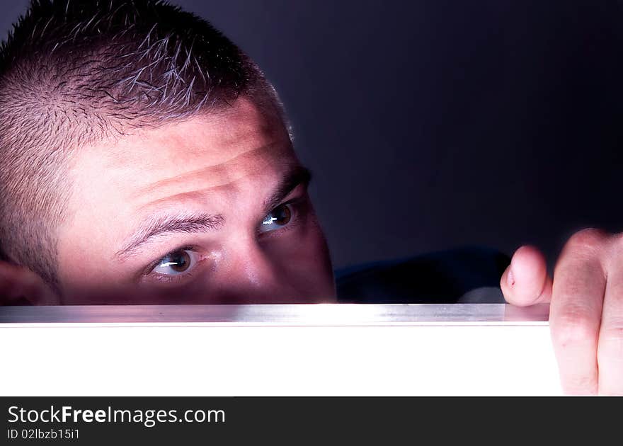 Young man hiding, studio shot