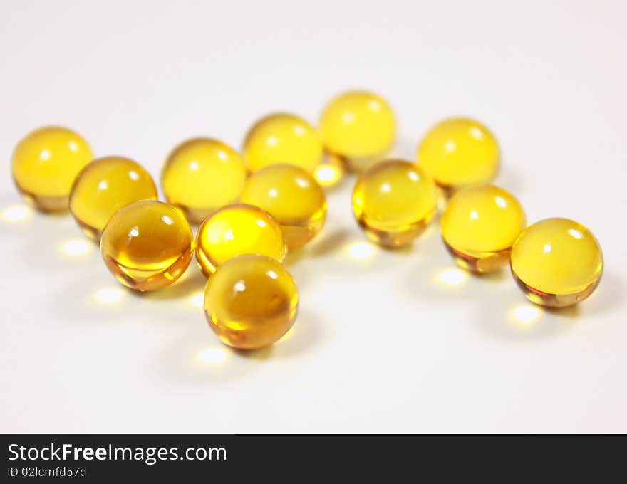 Dragees (vitamins) of yellow colour lie on a table