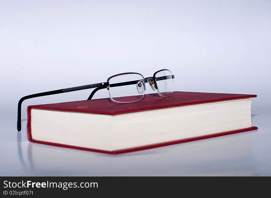 A pair of glasses on a red book. A pair of glasses on a red book.