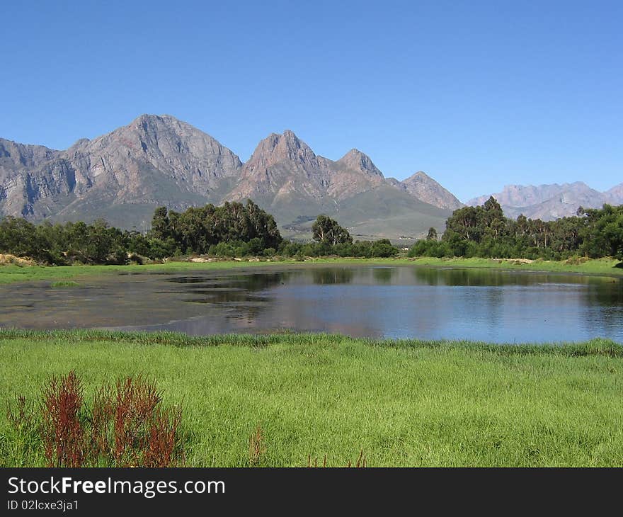 The Audensberg reflects in the waters of a nearby rural dam in Worcester, Western Cape, South Africa. The Audensberg reflects in the waters of a nearby rural dam in Worcester, Western Cape, South Africa