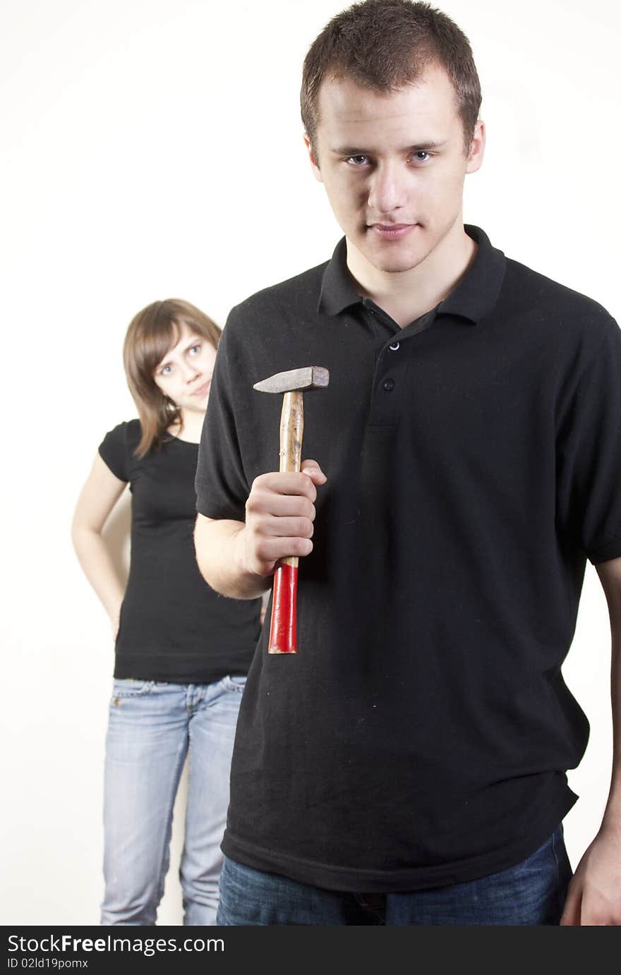 The picture presents a pair of people - woman, looking enquirely and man with a hammer, looking determinedly and trying to show, that he is dominant and stronger. The picture presents a pair of people - woman, looking enquirely and man with a hammer, looking determinedly and trying to show, that he is dominant and stronger.