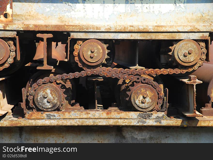 Old rusty gears of the machine on the grass. Detail shot of gears and sprockets. Old rusty gears of the machine on the grass. Detail shot of gears and sprockets.