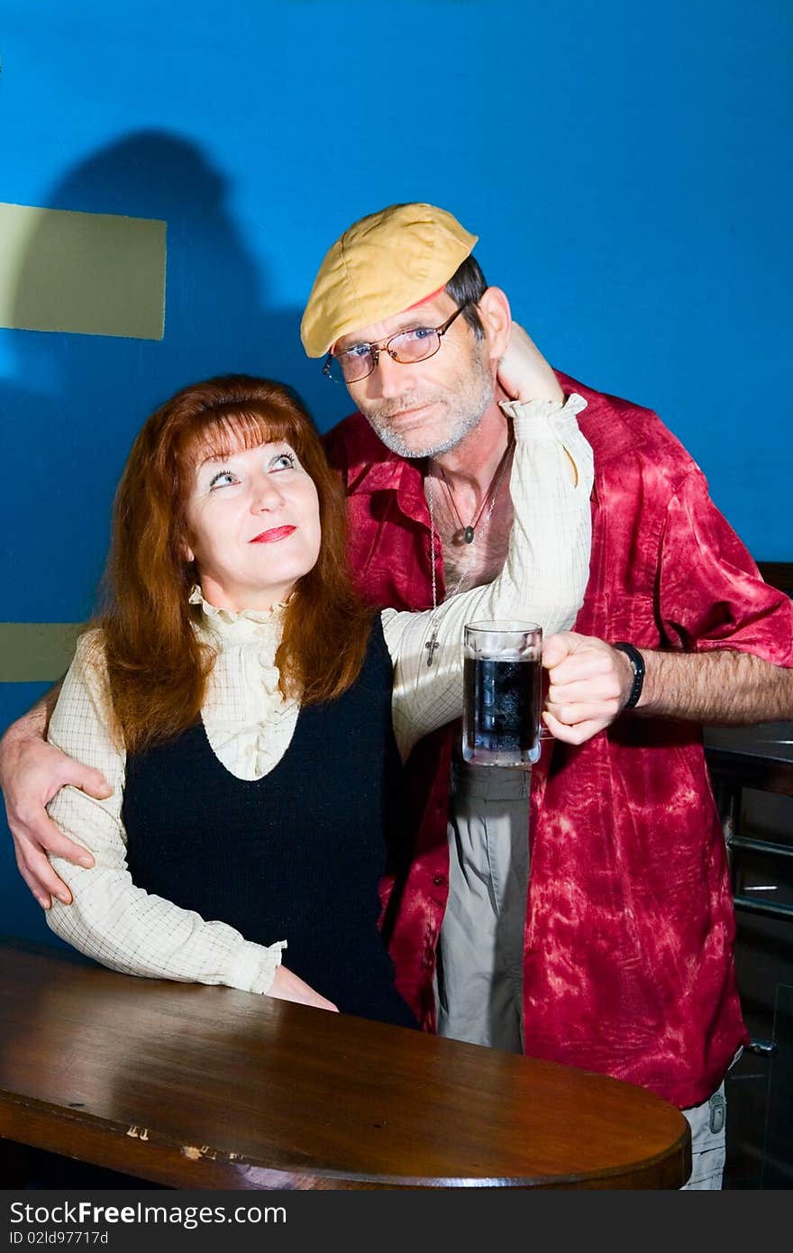 Red woman and man in cap with mug with beer