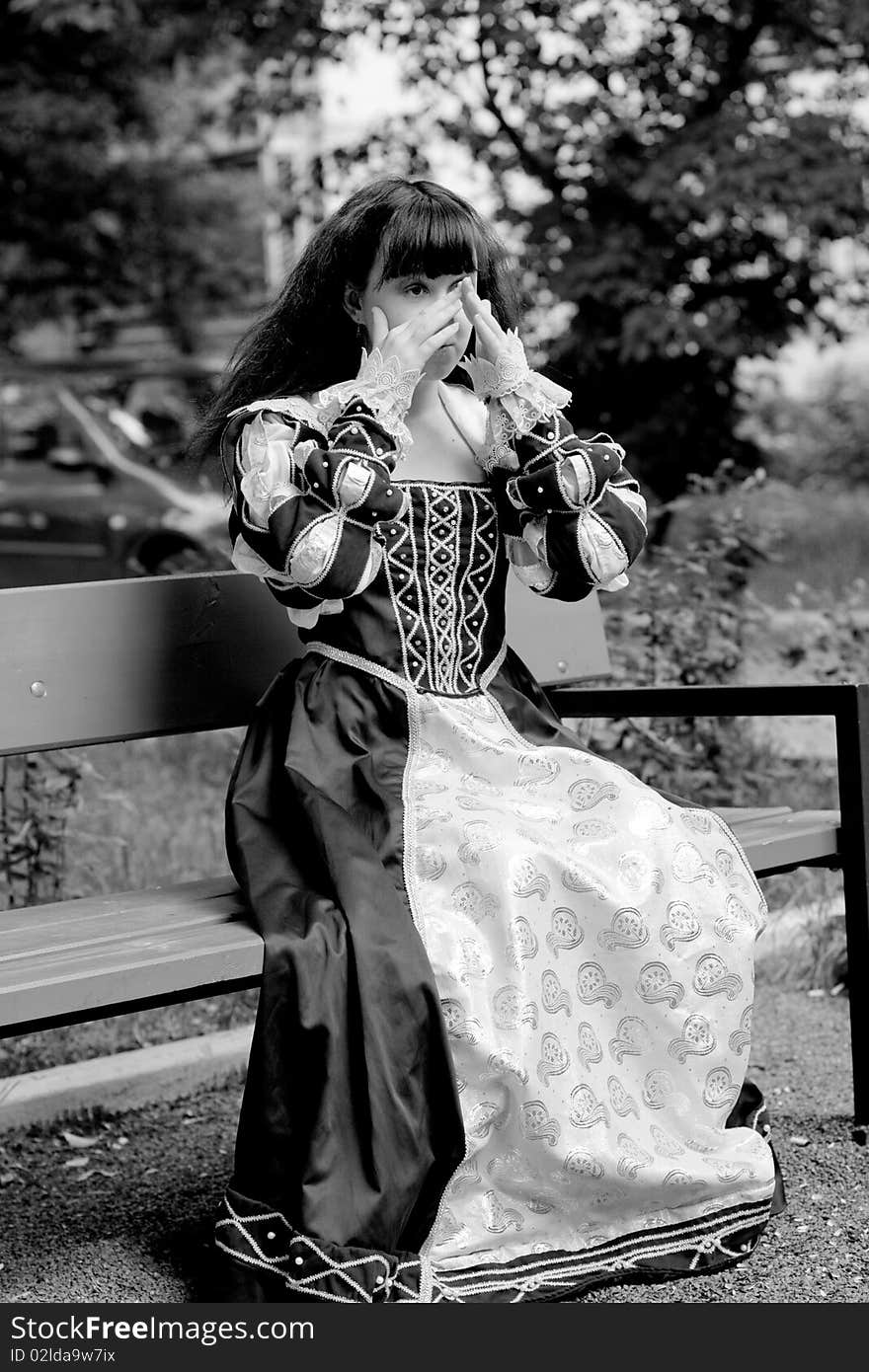 A girl in medieval dress sitting on a bench. A girl in medieval dress sitting on a bench