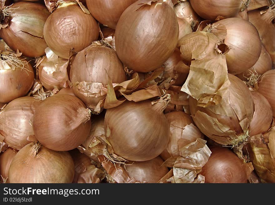 A background of lots of yellow onions piled up