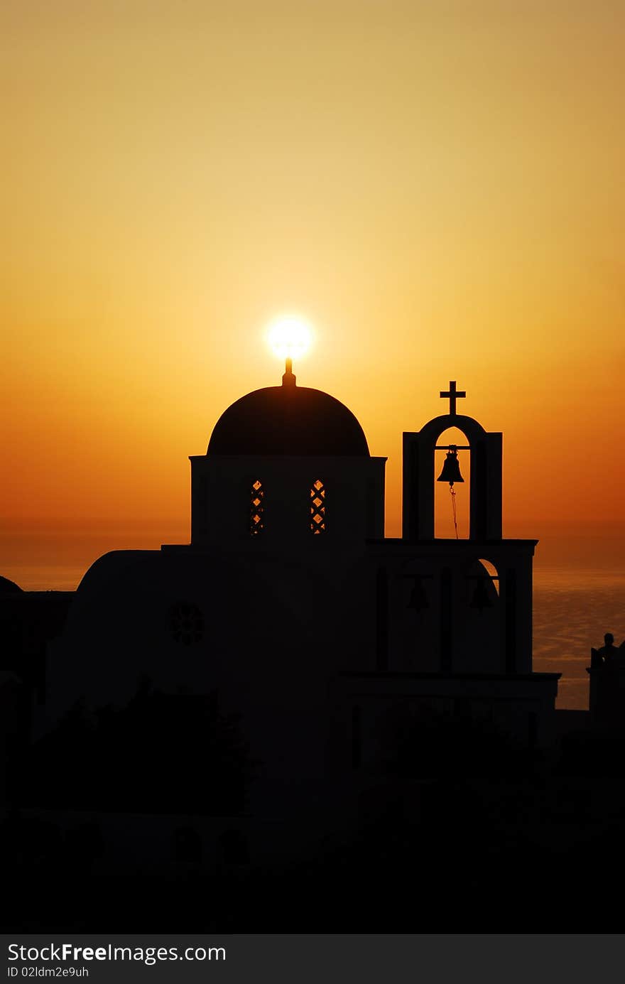 Santorini golden sunrise by a church, where the sun shines on top of the dome. Santorini golden sunrise by a church, where the sun shines on top of the dome