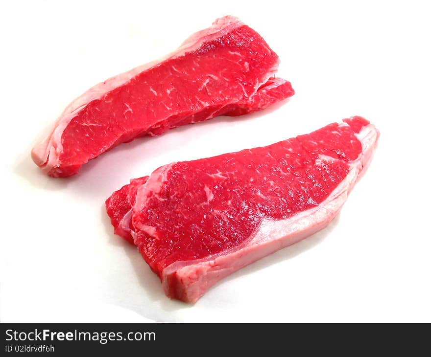 Two raw beef steaks on a white background. Two raw beef steaks on a white background