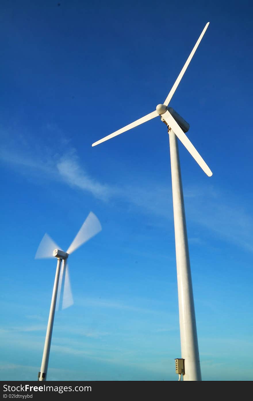 Two wind turbines one is motion another is standstill. Two wind turbines one is motion another is standstill.