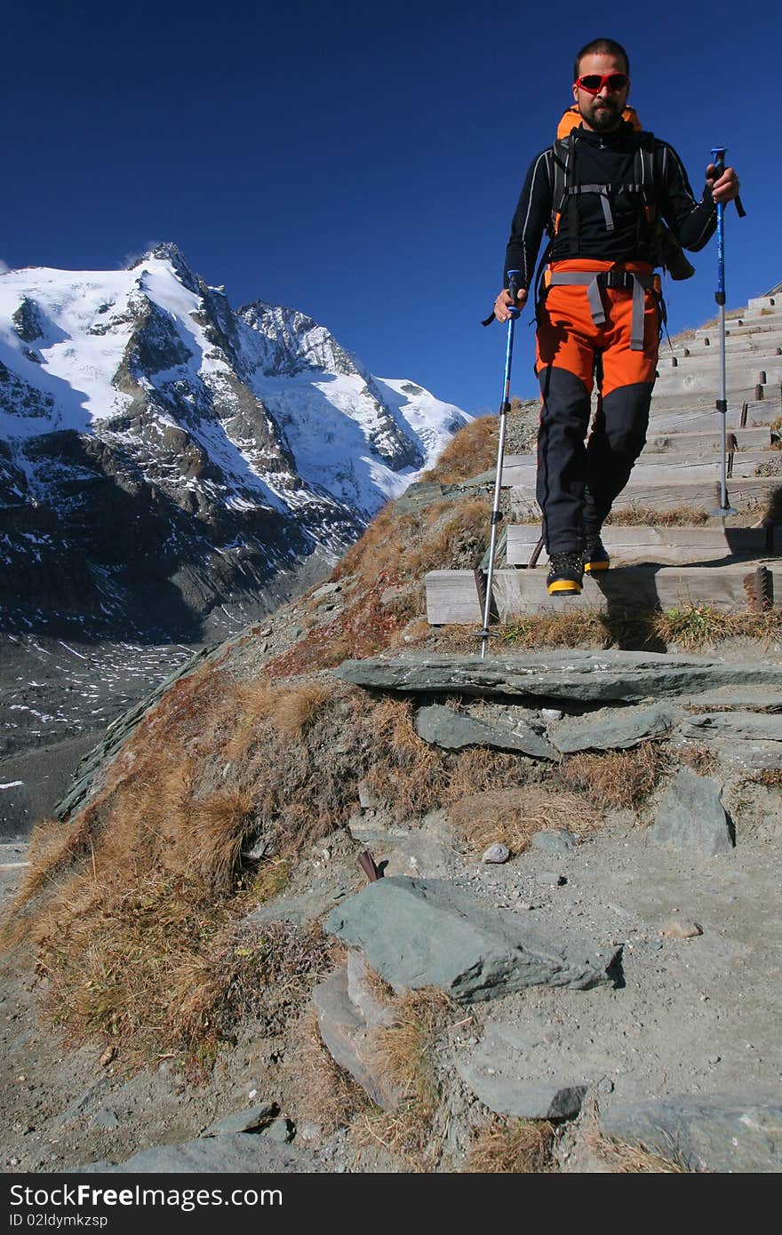 Male hiker in the mountains with snow covered peak in the background. Male hiker in the mountains with snow covered peak in the background