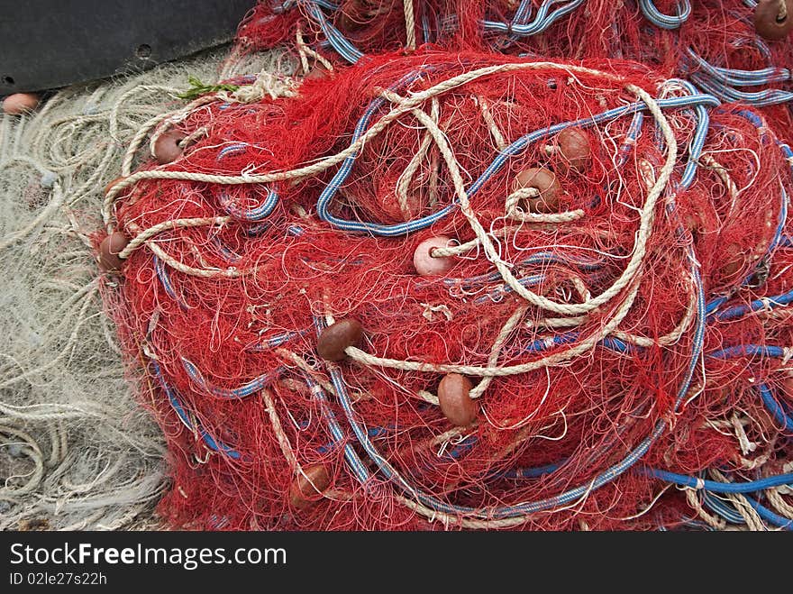 Heap of fishing nets with ropes and floats.