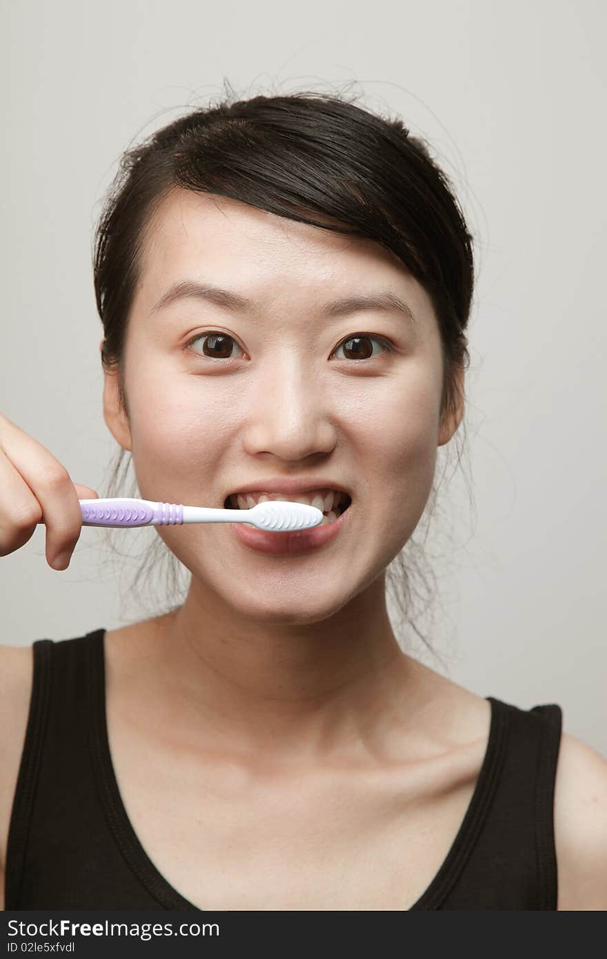 Attractive young woman brushing her teeth. Attractive young woman brushing her teeth