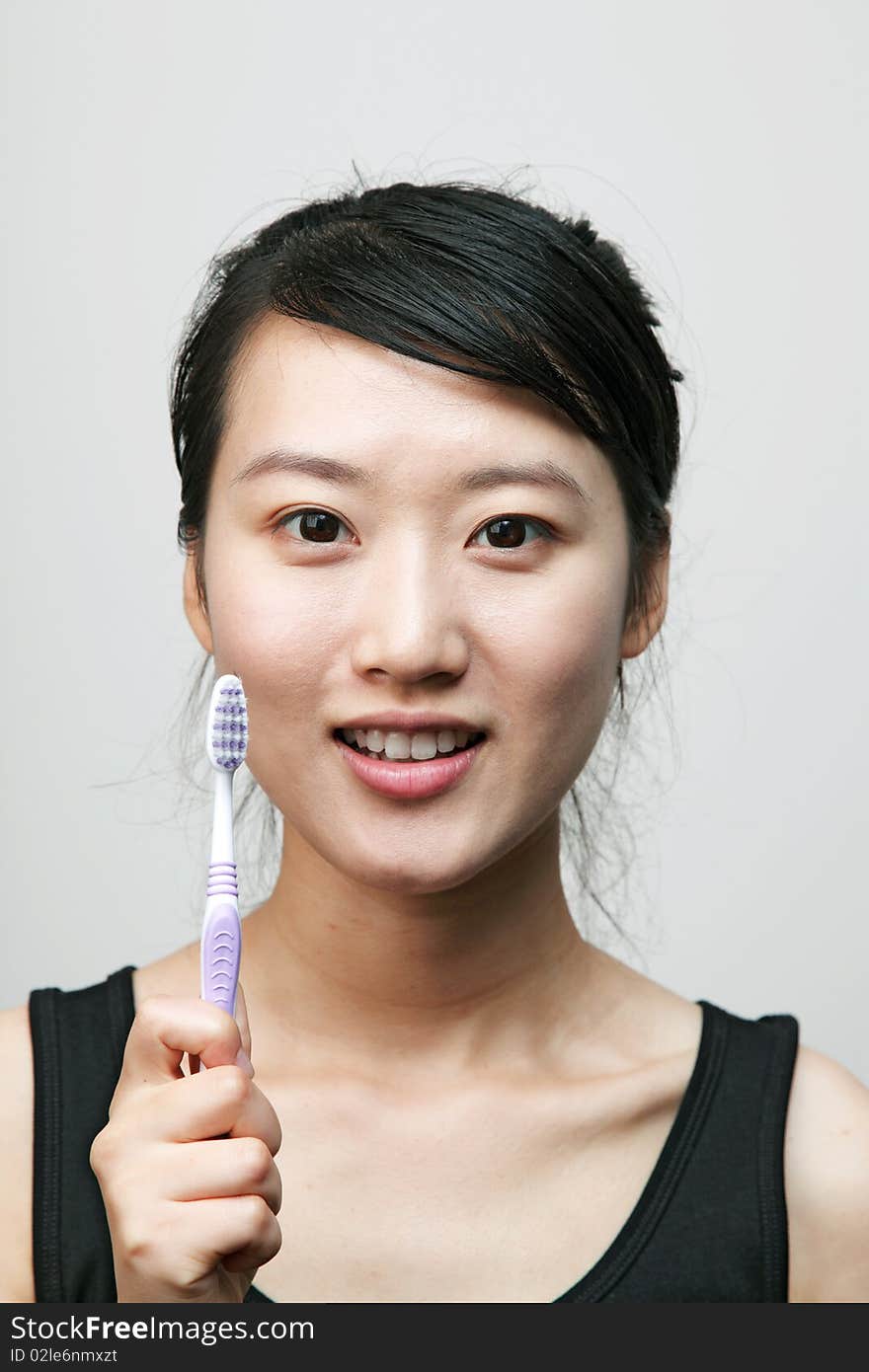 Attractive young woman brushing her teeth. Attractive young woman brushing her teeth