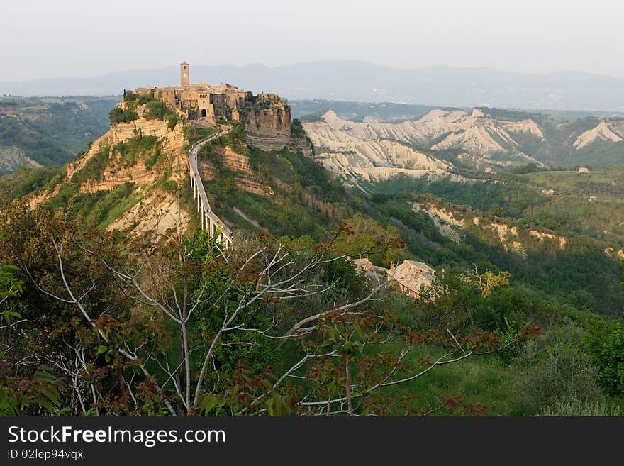 Civita di Bagnoregio is a town in the Province of Viterbo in Central Italy. It was founded by Etruscans over twenty-five hundred years ago. The town is noted for its striking position atop a plateau of friable volcanic tuff overlooking the Tiber river valley, in constant danger of destruction as its edges fall off, leaving the buildings built on the plateau to crumble. Civita di Bagnoregio is a town in the Province of Viterbo in Central Italy. It was founded by Etruscans over twenty-five hundred years ago. The town is noted for its striking position atop a plateau of friable volcanic tuff overlooking the Tiber river valley, in constant danger of destruction as its edges fall off, leaving the buildings built on the plateau to crumble.